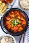 Overhead view of gochujang jjigae served with rice and Korean banchan