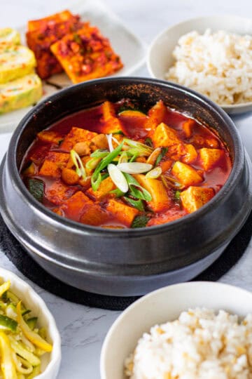 Gochujang jjigae with chicken, tofu, potato, and zucchini served with rice and Korean side dishes