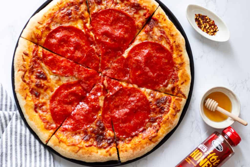 Homemade hot honey pepperoni pizza with melted mozzarella and large pepperoni slices