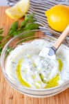 Close-up of creamy homemade small batch tzatziki sauce with olive oil and dill