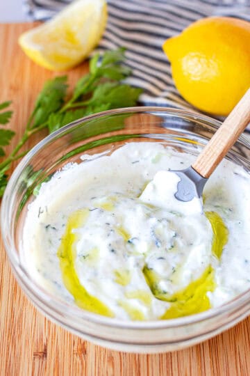 Close-up of creamy homemade small batch tzatziki sauce with olive oil and dill