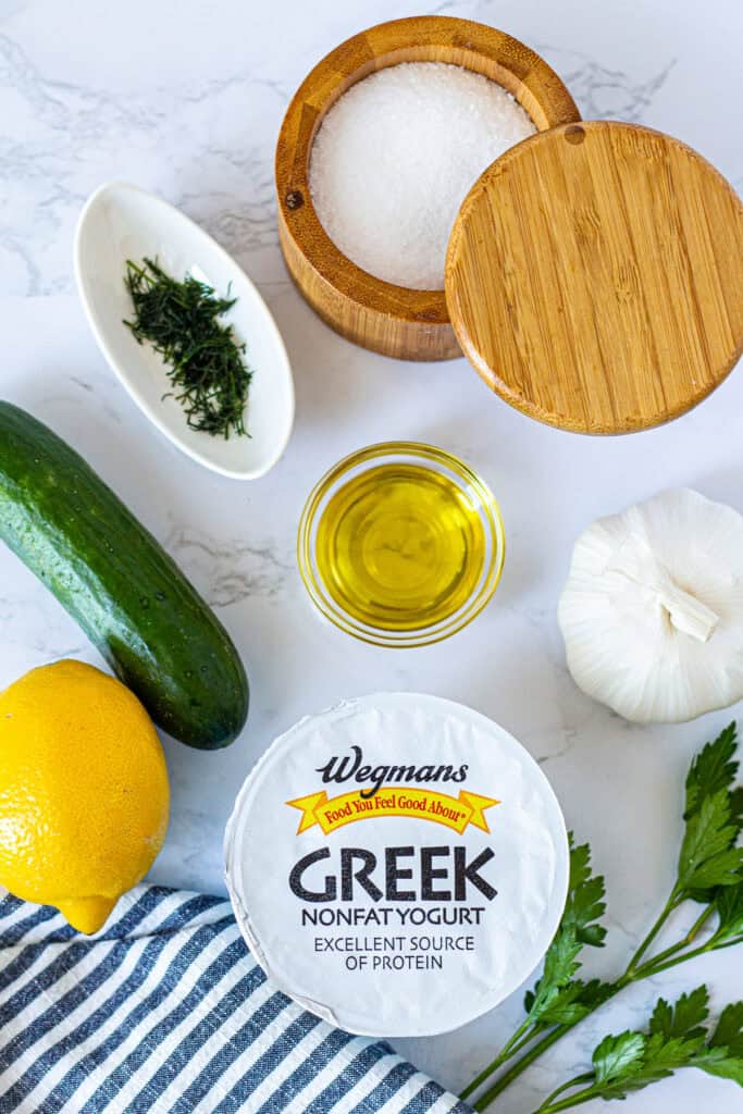 Ingredients for making small batch tzatziki sauce, including Greek yogurt, Persian cucumber, garlic, lemon, olive oil, and fresh dill