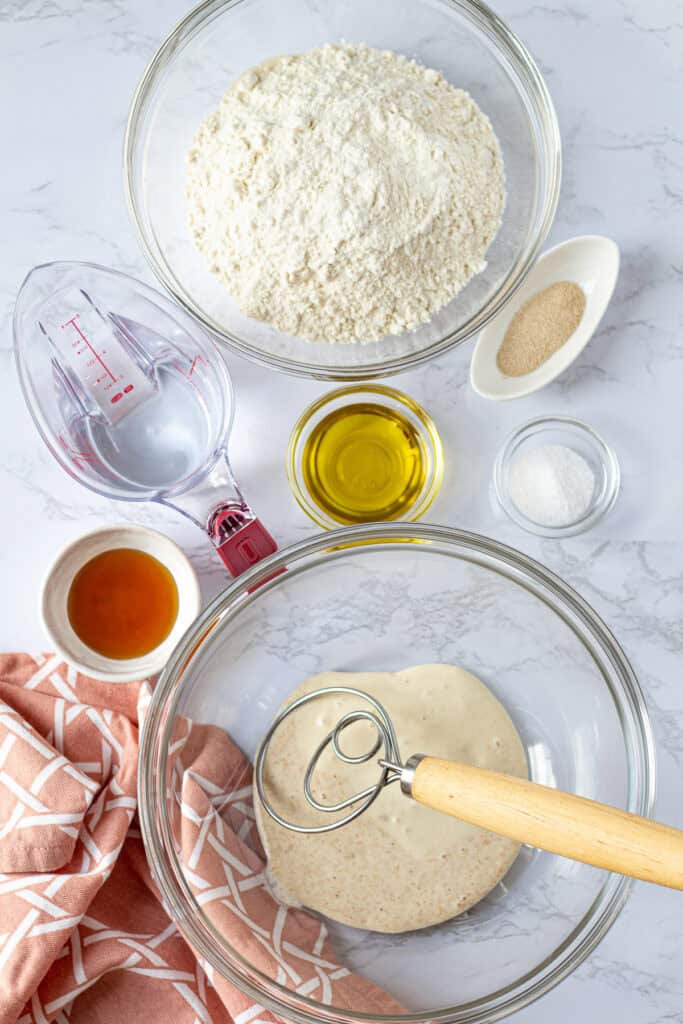 Ingredients for sourdough discard French bread, including discard, bread flour, water, honey, olive oil, yeast, and salt.