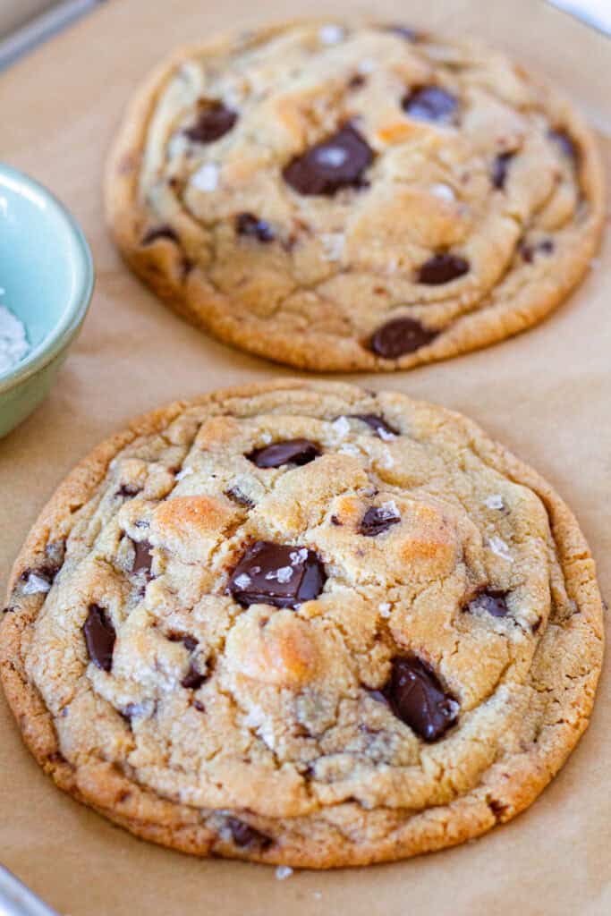 Large freshly baked chocolate chip cookies with melted dark chocolate and flaky sea salt