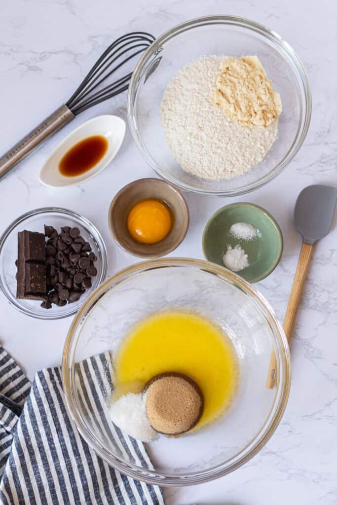 Ingredients for small batch chocolate chip cookies with melted butter, sugars, bread flour, malted milk powder, egg yolk, vanilla, and chocolate