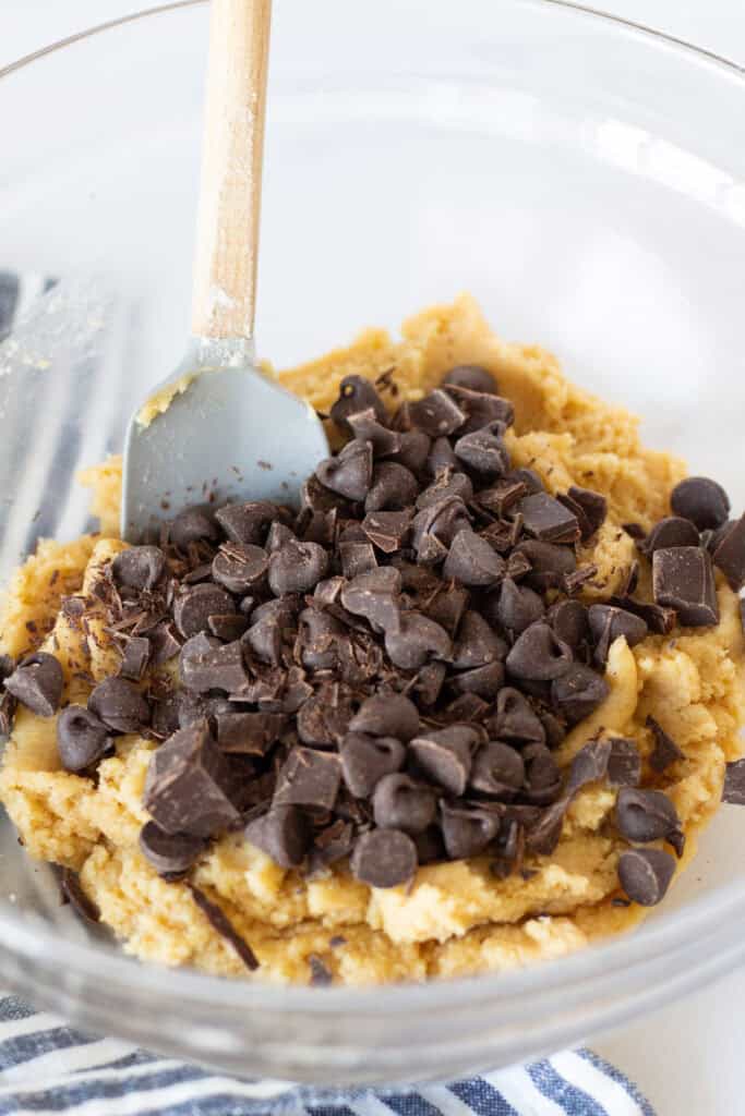 Chopped dark chocolate and semisweet chocolate chips being added to chocolate chip cookie dough